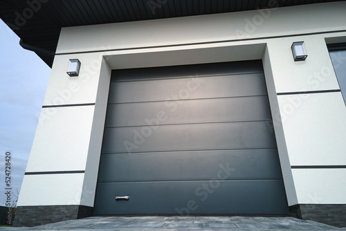 Automatic electric roll-up commercial garage gate or push-up door in modern private building ground floor