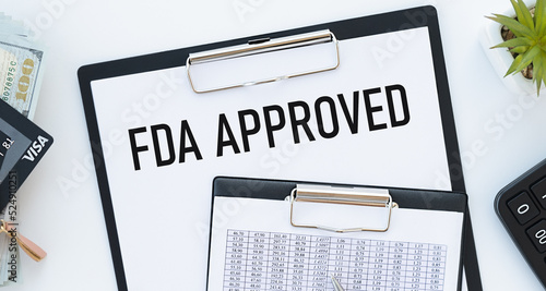 Stickers with pencils and notebook with text FDA APPROVED ona chart background