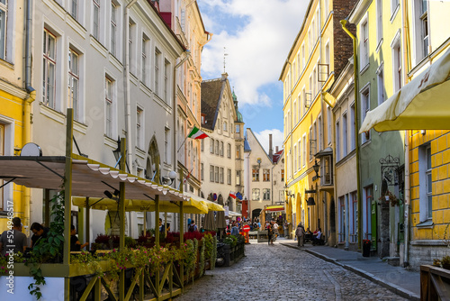 A picturesque cobbled street of sidewalk cafes and shops near the Bishop's House in the medieval old town of Tallinn, in the Baltic region of Northern Europe.