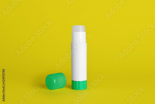 Blank glue stick and cap on yellow background