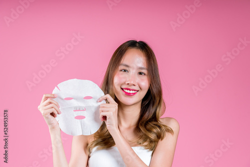 Facial sheet mask treatment cosmatic and spa, Beauty young asian woman on her face, heath care on the pink background