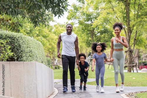 Happy African American family running together outdoor in the park