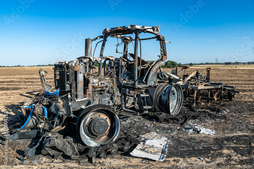 Feux de champs, carcasse de tracteur et d'un déchaumeur calciné suite à un incendie de chaumes lors de forte canicule