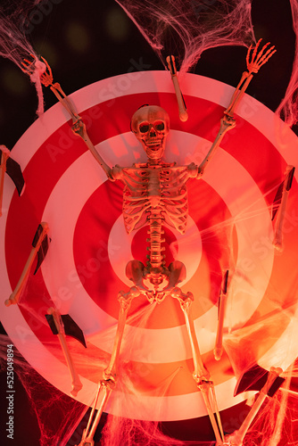 crucified skeleton with axes in red neon light on the target. Halloween