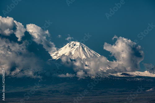 a snow-covered mountain behind the clouds
