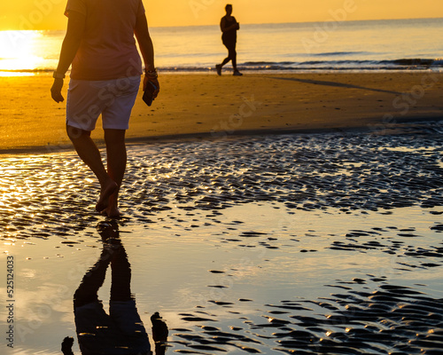 Sunrise photos at Burkes Beach on Hilton Head Island SC with people walking on tidal flats.