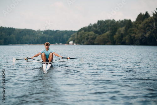 Sportsman single scull man rower rowing technique on boat. Paddle oar splash movement