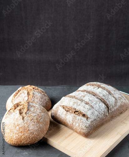foto en vertical de pan tradicional sobre fondo negro y madera