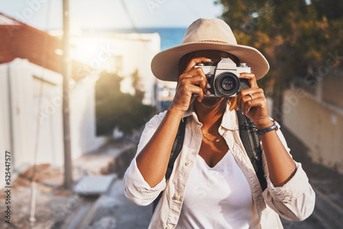 Photographer, travel or tourist taking pictures or photos outdoors in a new town. Traveler using a camera while on a trip at a vacation or holiday location on a sunny day doing a photoshoot