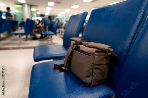 Low light view. Brown crossbody bag is on seat in the room. Because people forget after sitting ready get up and leave.