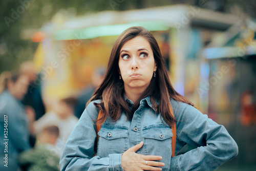 Woman Feeling Hungry Looking for Something to Eat in Amusement Park. Person accusing stomachaches after eating street food at funfair festival 