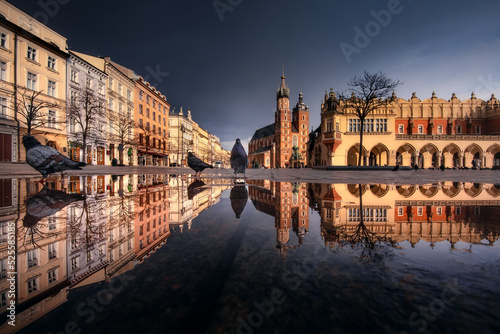 The main square in Krakow with a view of the cloth hall, St. Mary's Basilica in a natural mirror. Rynek główny w krakowie z widokiem na sukiennice, bazylikę mariacką w naturalnym lustrze.