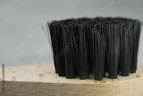 Dry natural bristle brush with wooden handle for anti cellulite massage. Close-up of massage brush for skin