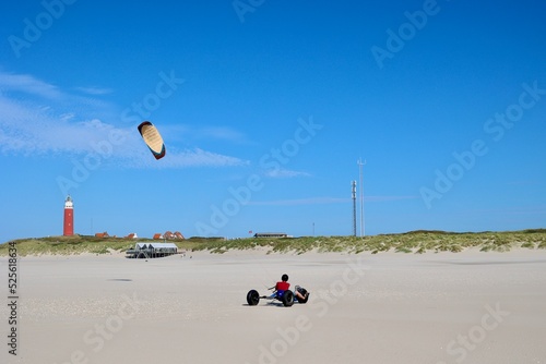 Kite Buggy on the beach of Texel Island, The Netherlands. View of the historical red lighthouse. 