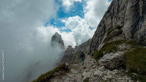 woman hiking and climbing the via ferrata "via delle bocchette" mountain sign in the brenta Dolomites in Italy