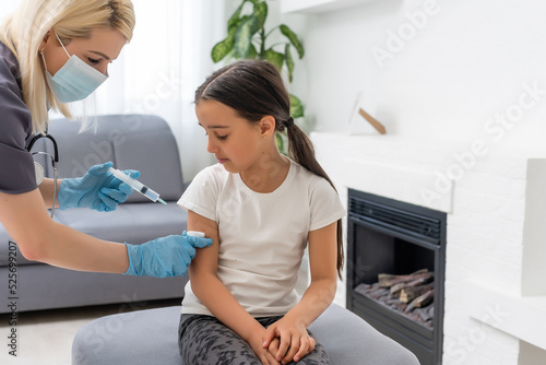 nurse giving vaccination injection to little girl patient