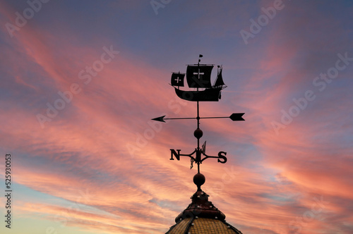 Silhouette of weathervane at sunset. The weathervane is a Spanish ship under full sail.