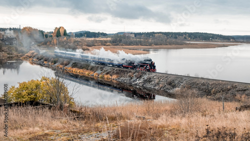 Russia Karelia is city of Sortavala Historic old steam train with a wagon rides along the embankment of Lake Ladoga