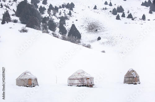 Yurts in winter. National ancient house of the peoples of Kyrgyzstan and Asian countries. national housing. Yurts against the backdrop of snow and highlands. Yurt camp for tourists.