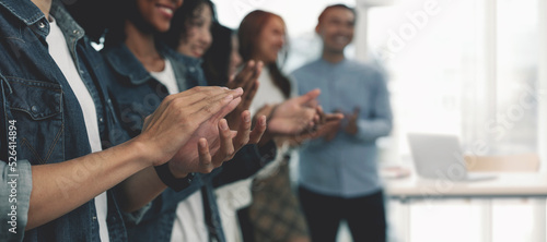 Happy group of young hipster businesspeople clapping in office.