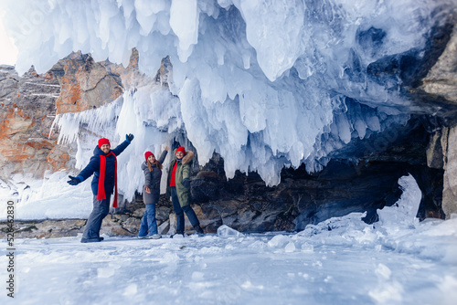Adventure extreme group people tourist background of frozen grotto and pure ice winter Lake Baikal