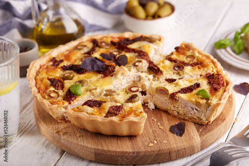 Quiche open tart pie with chicken meat, green olives and sundried tomatoes. Savory taste. Italian cuisine.