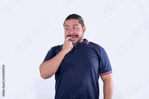 A man bites his finger nervously knowing he is in deep trouble. Reaction after committing a huge mistake. Isolated on a white background.