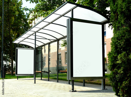 bus shelter with blank poster and advertising billboard sign. background image for mock-up. empty ad space and placeholder. buststop with soft green background. transit and transportation.