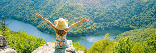 woman sitting on the mountain peak and amazing view of dordogne river and forest