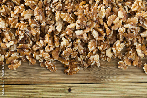 Natural background - heap of peeled walnuts scattered on wooden surface