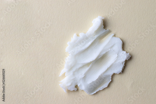 White creamy texture of clean cleansing butter on beige background.Cosmetic swatch
