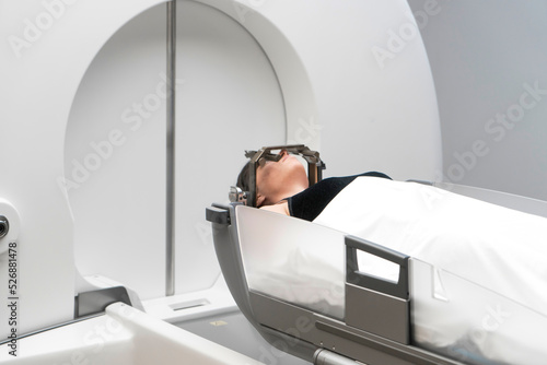 The patient lies in front of the device for the treatment of cancer with a gamma knife. She has a metal clip cap on his head. Gamma Knife stereotactic radiosurgery.