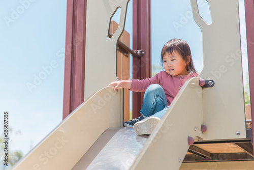 公園の滑り台で遊ぶ子供（女の子） 