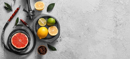 Parts of hookah and citrus fruits on light background with space for text