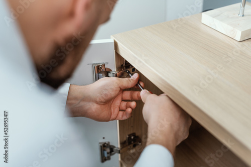 Man repairing a cabinet door hinge