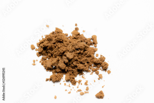 heap of brown powder on white background. powdered herbs or dietary supplements or cocoa. dry tobacco powder 