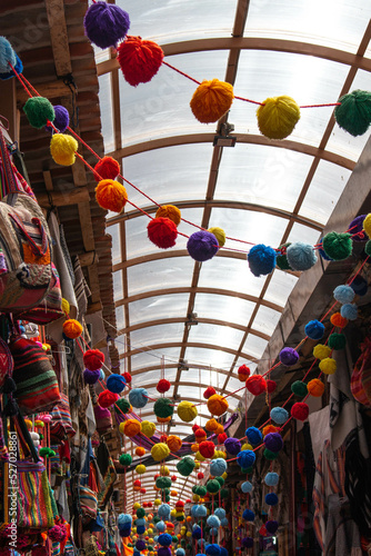 Inside the new handicraft market of Pisac, decorated with colorful pompoms and various typical products, in Peru. 