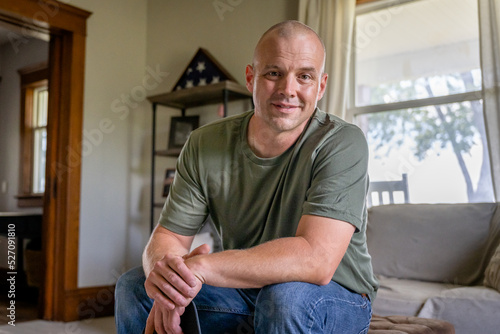 Marine veteran at home with family poses for portrait.