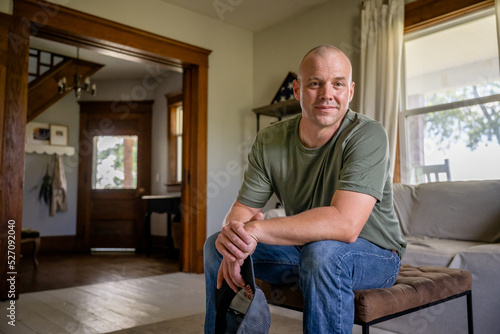 Marine veteran at home with family poses for portrait.