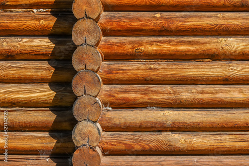 A log wall construction with a swedish cope log profile. A heavily cracked wooden wall as a background