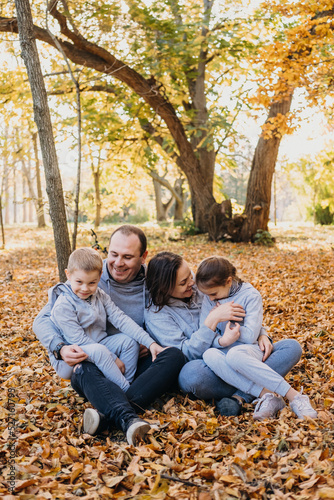 Portrait of a family with children posing together, playing and having fun in autumn city park. People lifestyle concept. Family concept. Autumn forest. Happy