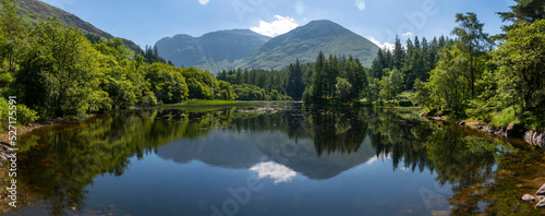 Small Scottish lake panoramic landscape,surrounded by trees at Glencoe,Scotland,United Kingdom.