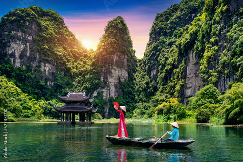 Asian woman wearing Vietnam culture traditional at Trang An, Vietnam.