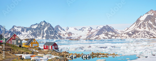 Panoramic view of colorful Kulusuk village in East Greenland - Kulusuk, Greenland - Melting of a iceberg and pouring water into the sea