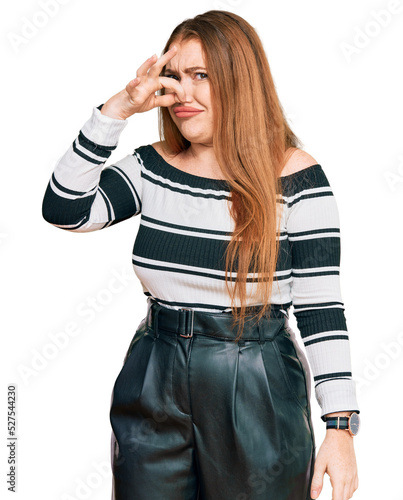 Young beautiful redhead woman wearing elegant clothes smelling something stinky and disgusting, intolerable smell, holding breath with fingers on nose. bad smell