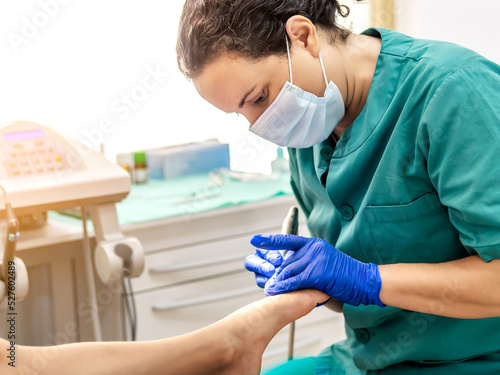 Female podiatrist doing chiropody in her podiatry clinic. Selective focus