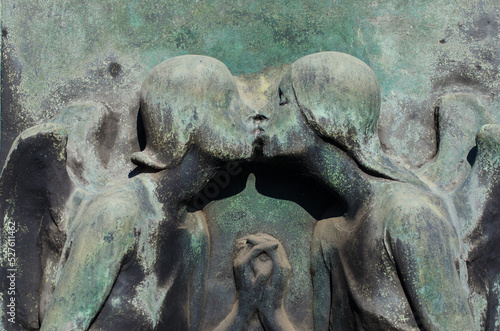 Il bassorilievo bronzeo di due angeli che si baciano su una tomba dell cimitero maggiore di Milano