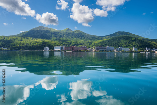 鏡のように青空、白い雲、有珠山、温泉街を映す洞爺湖面