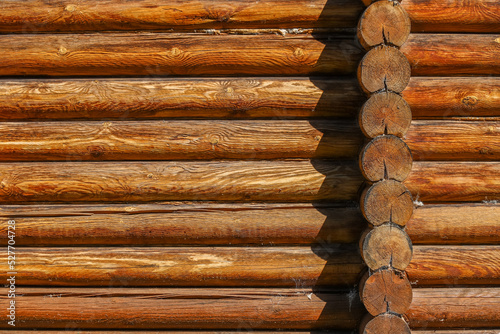 A log wall construction with a swedish cope log profile. A heavily cracked wooden wall as a background