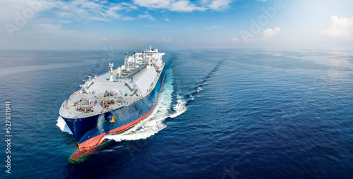 Front view of a big LNG tanker ship traveling with full speed over the calm, blue ocean as a concept for international fuel industry with copy space